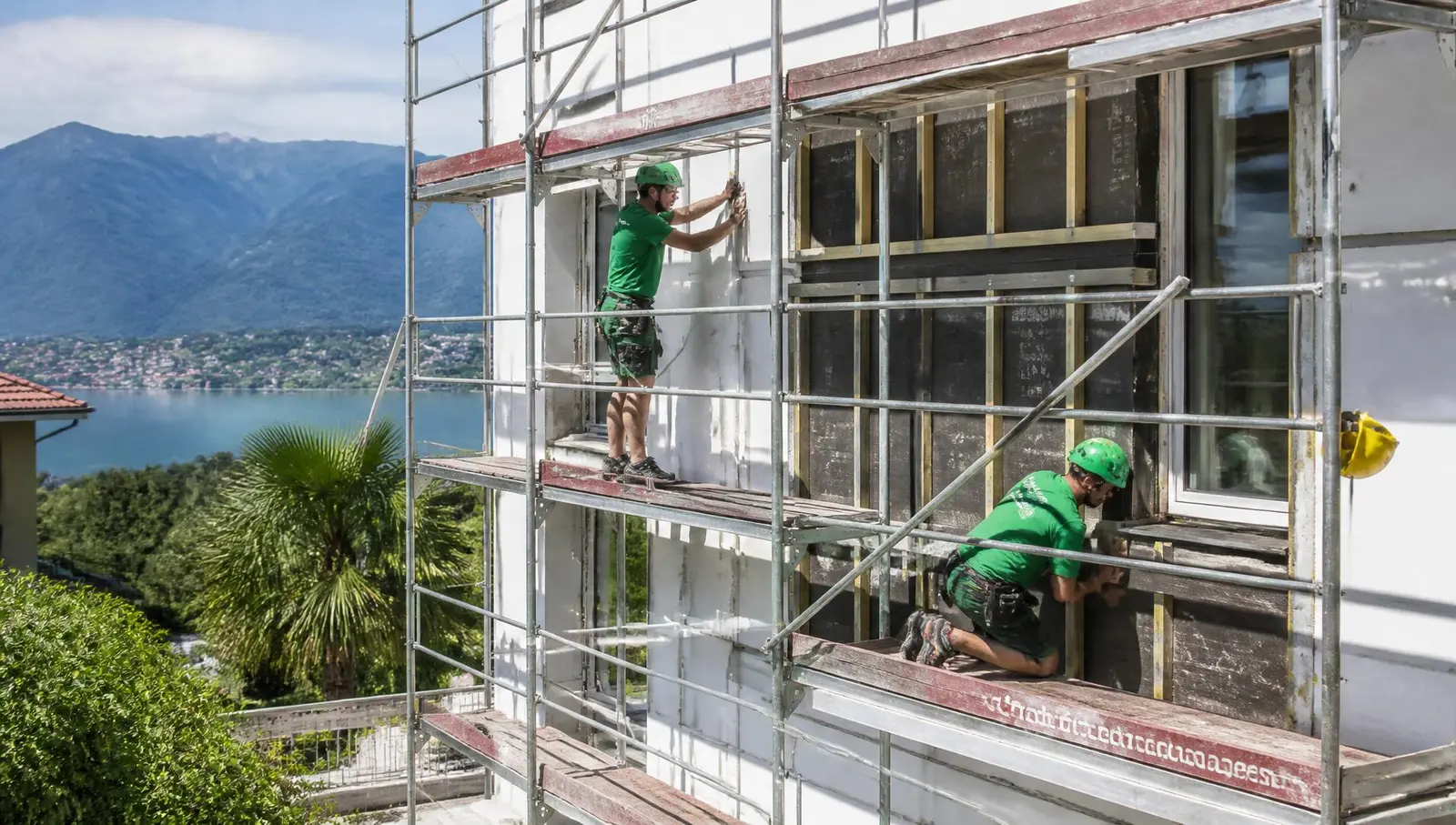 Operai al lavoro sulla facciata di una casa in Ticino